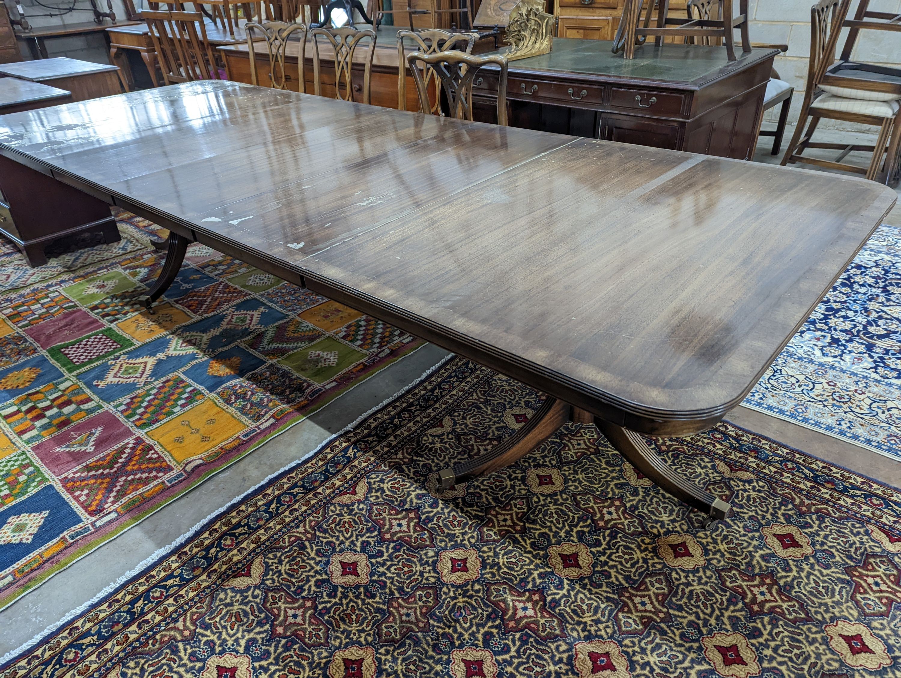 A reproduction mahogany twin pillar extending dining table together with twelve Georgian style dining chairs (two with arms)